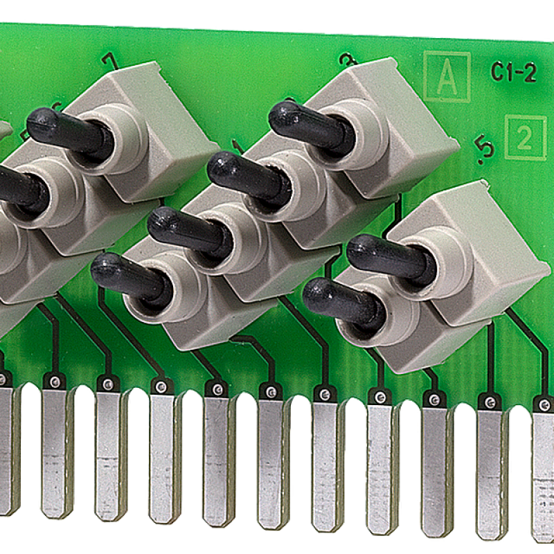 نمای نزدیک از یک برد مدار سبز با شش سوئیچ مختلف